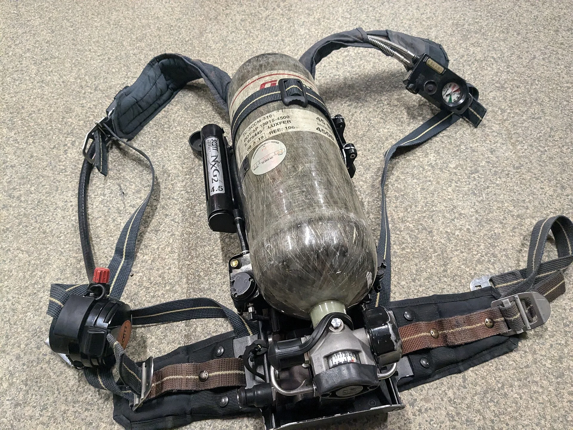 Self-contained breathing apparatus with composite air cylinder and harness laid on carpet