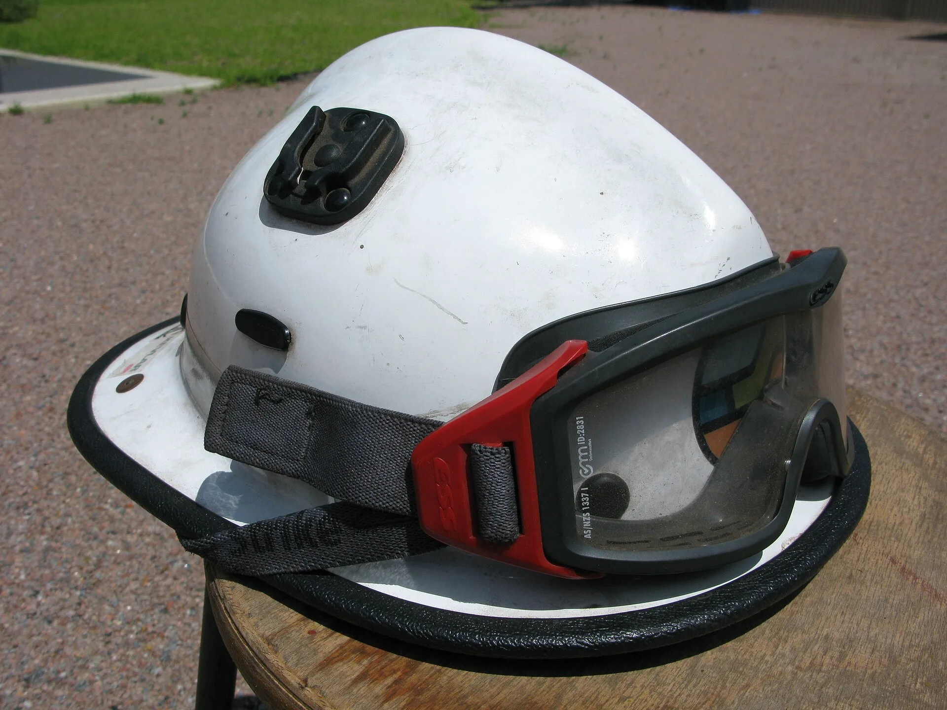 White Kevlar firefighter helmet fitted with protective goggles