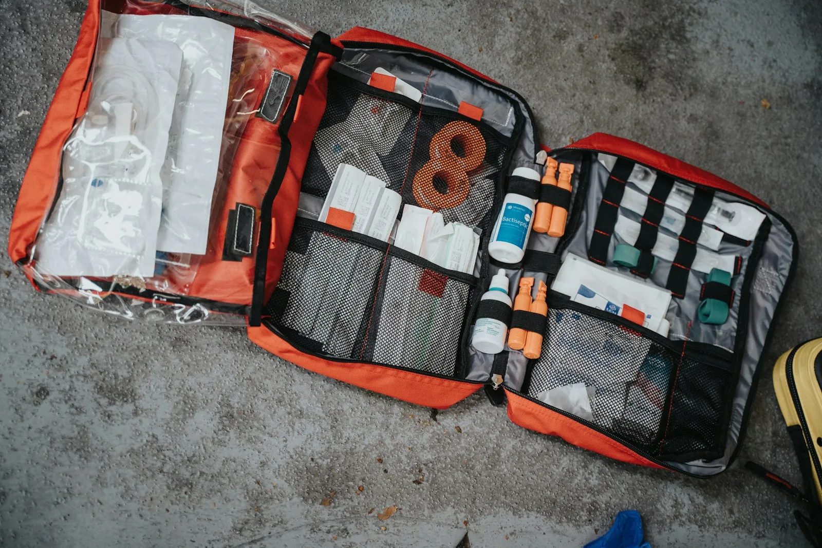 Open red first-responder first aid bag packed with bandages and medical supplies