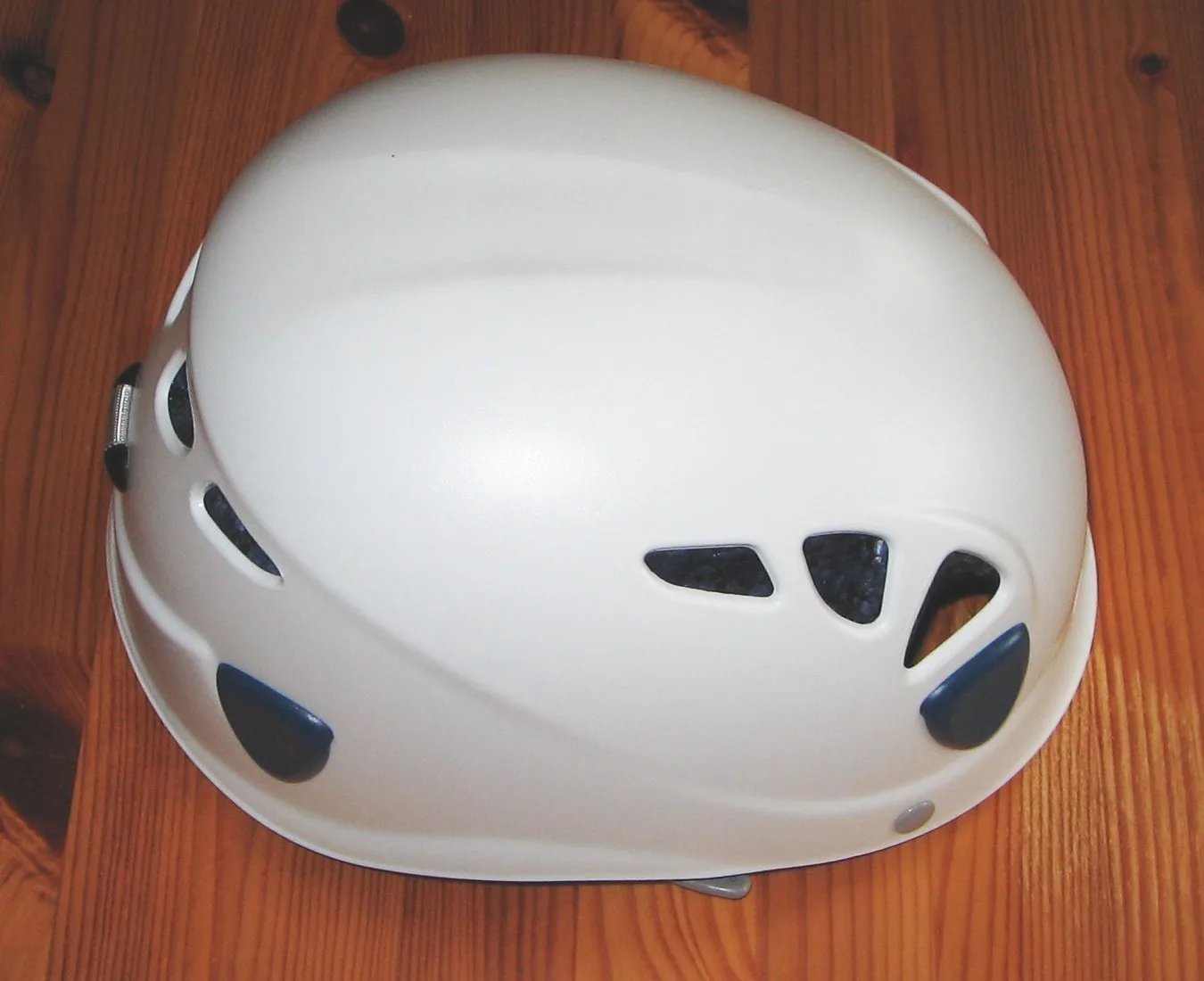 White vented climbing helmet on a wooden surface