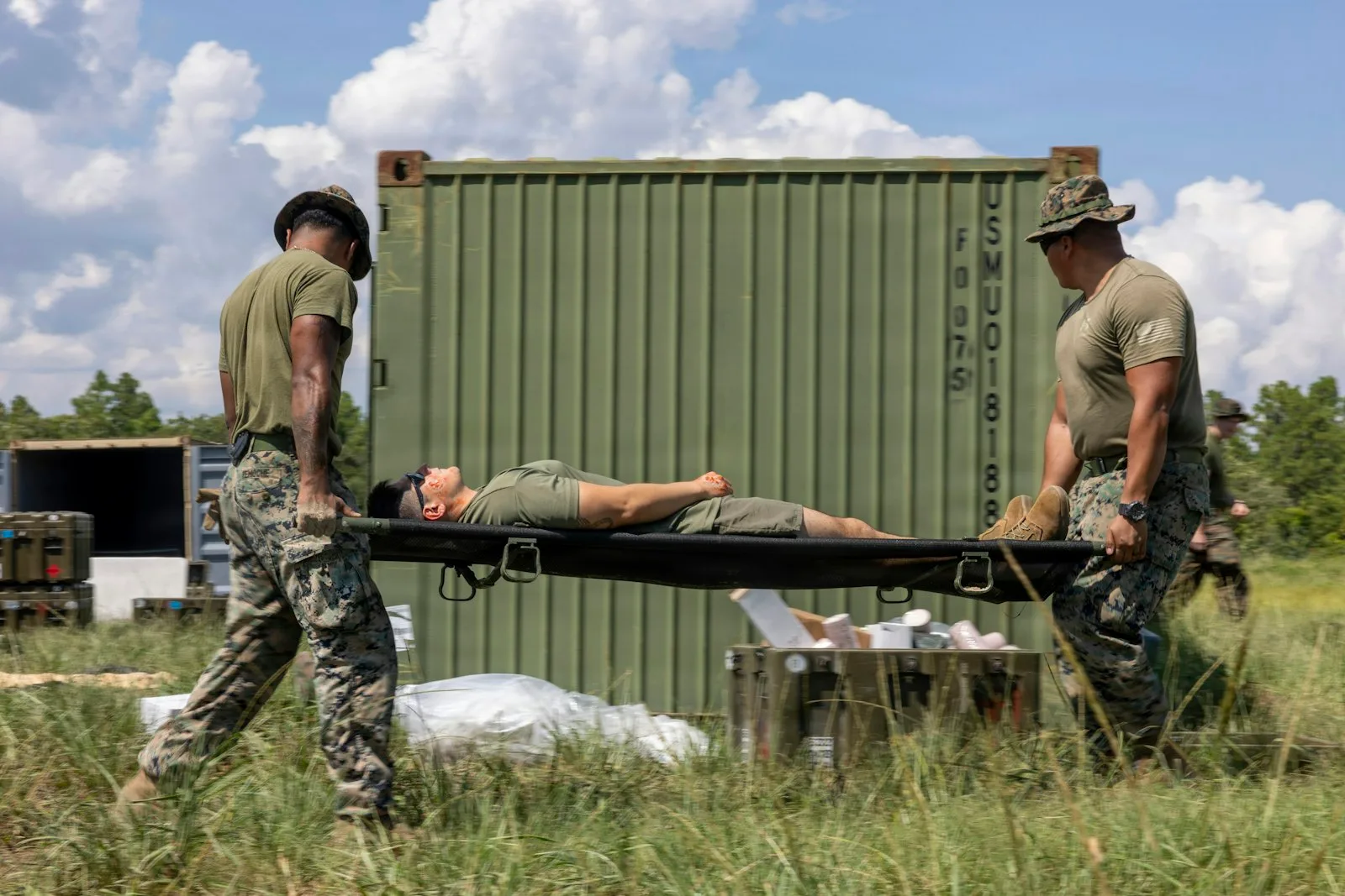 Two responders carrying a casualty on a folding field stretcher during an exercise