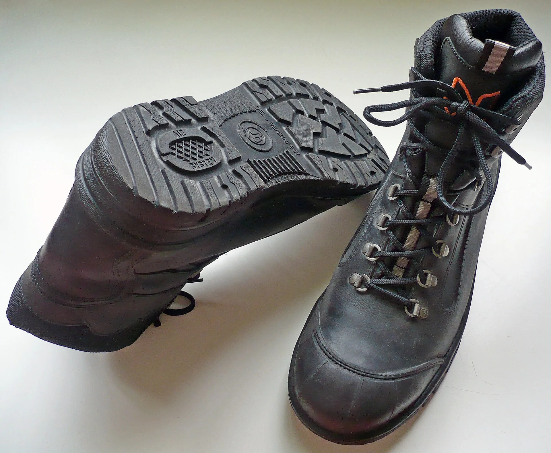 Pair of black leather S3 safety boots, one showing the slip-resistant tread