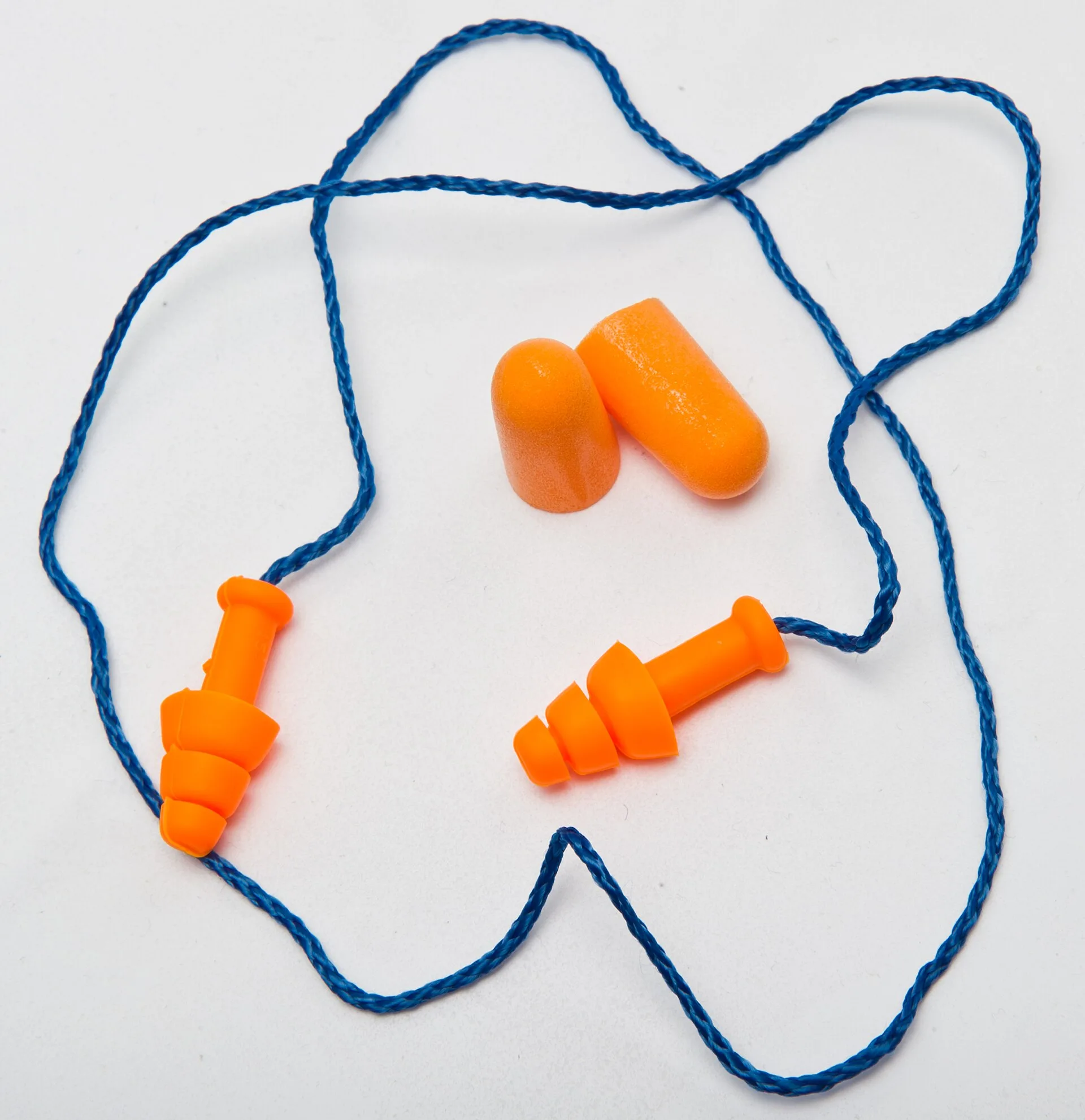 Orange reusable flanged earplugs on a blue cord beside a pair of foam earplugs