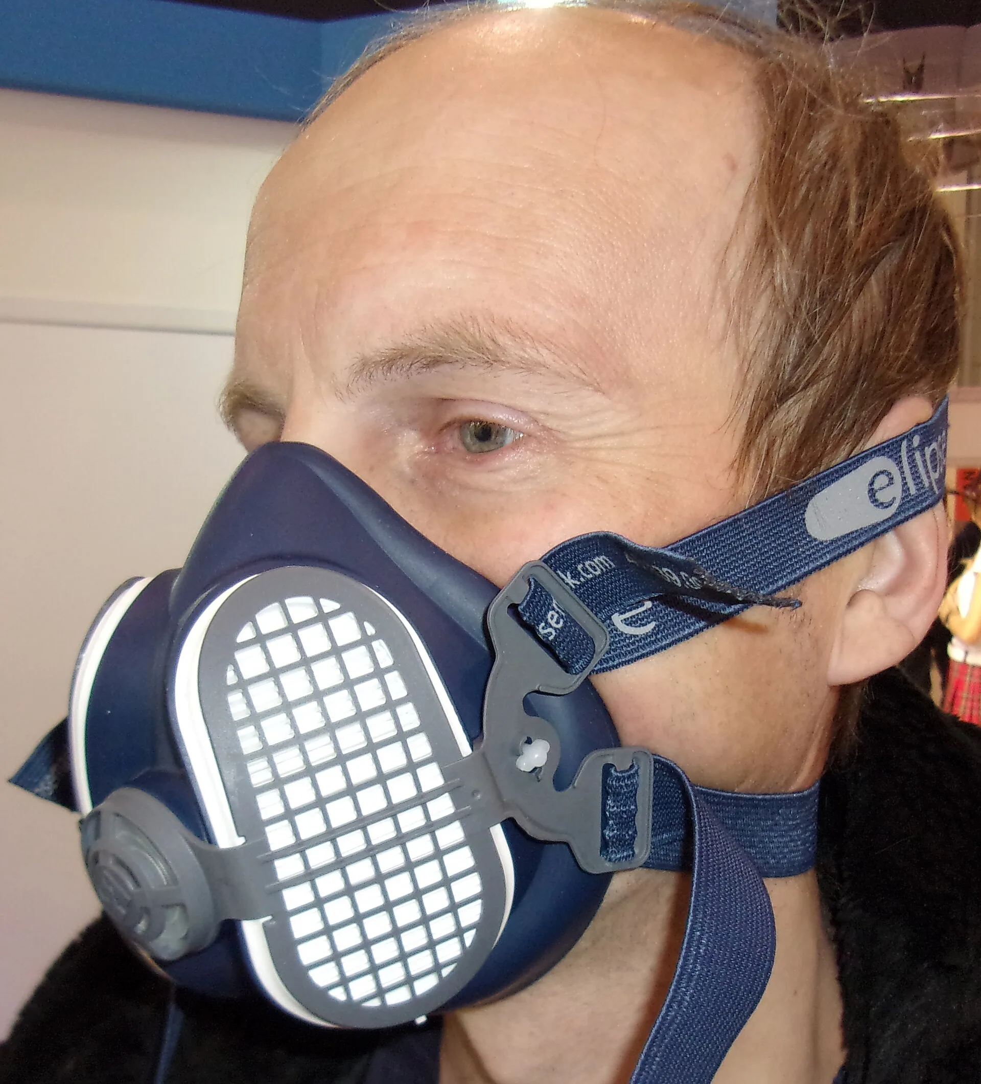 Man wearing a blue half-mask respirator with grey particulate filters