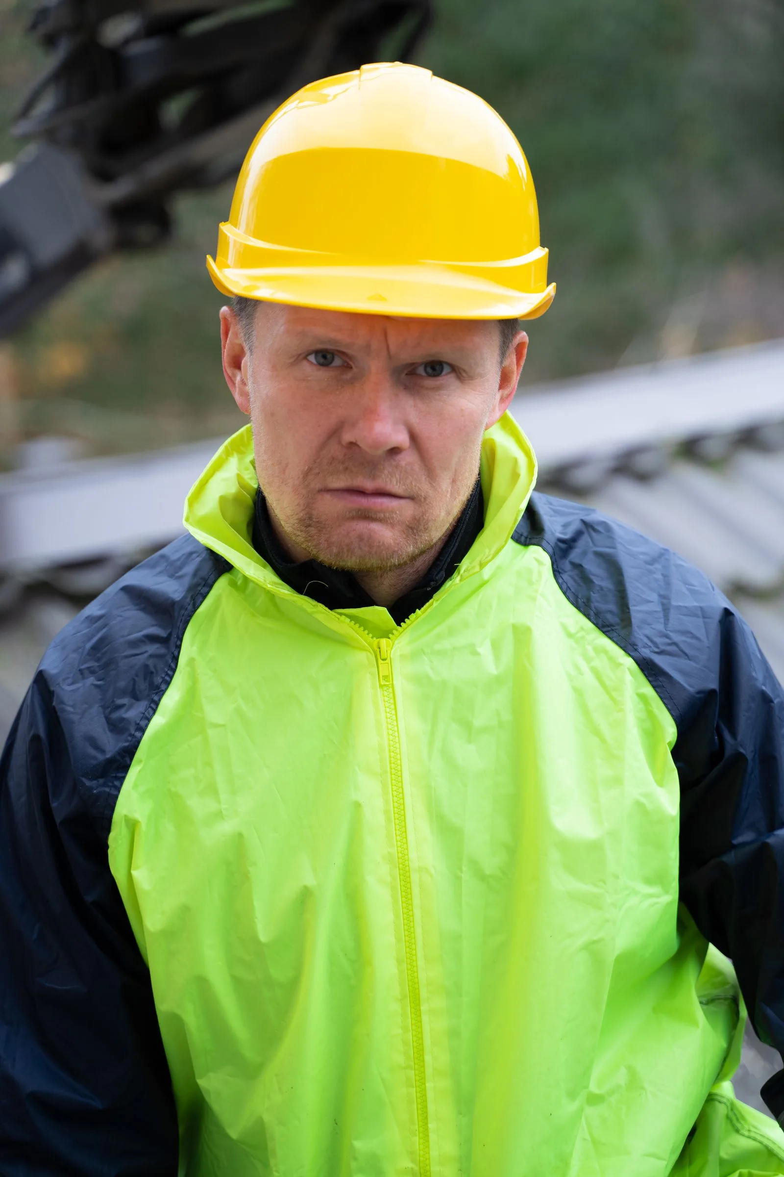 Worker in a fluorescent yellow high-visibility jacket and yellow hard hat
