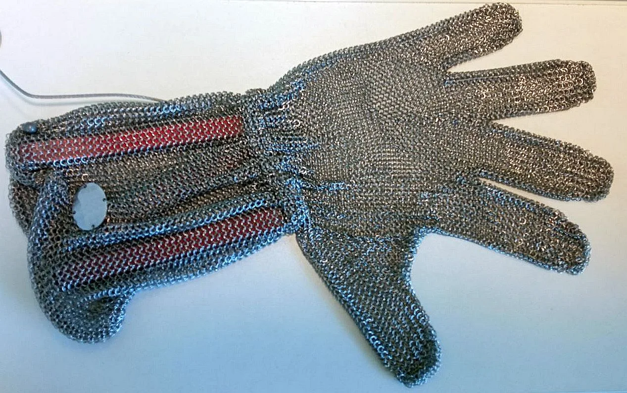 Stainless-steel chainmail cut-protection glove on a white surface