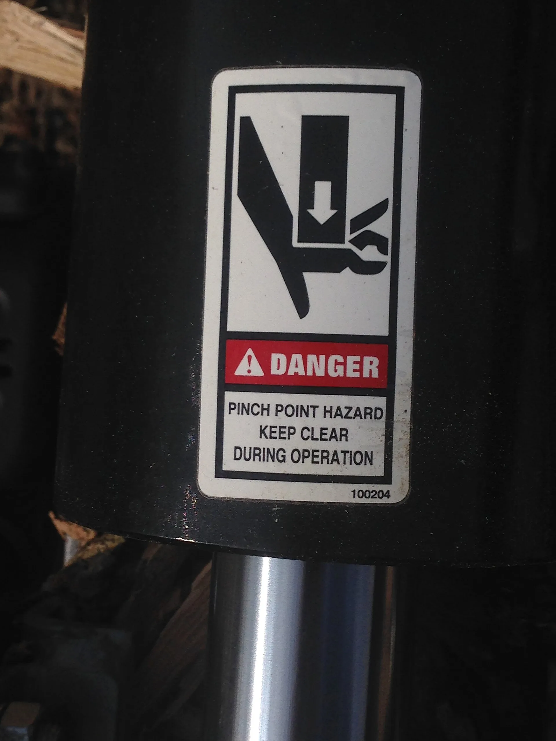 DANGER pinch point hazard label on machinery: keep clear during operation