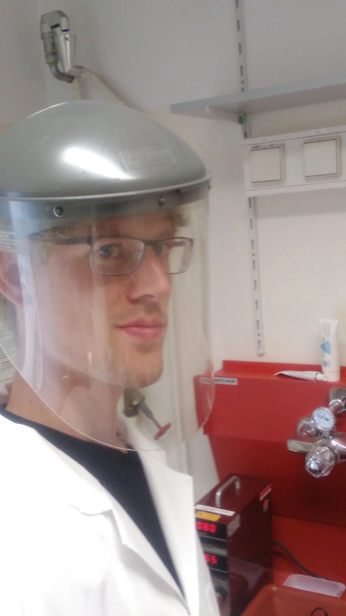 Laboratory worker wearing a clear UV-protective face shield on a headgear