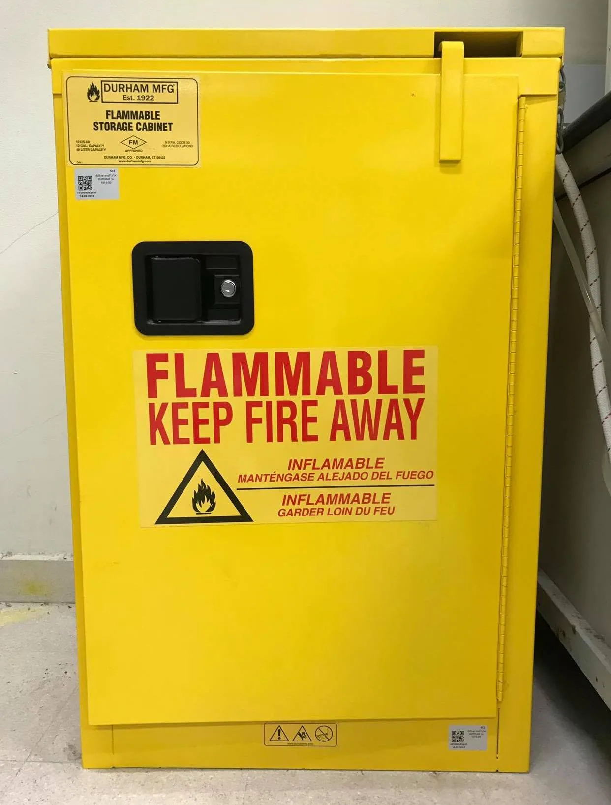 Yellow steel flammable liquid storage cabinet with FLAMMABLE KEEP FIRE AWAY label and hazard pictogram