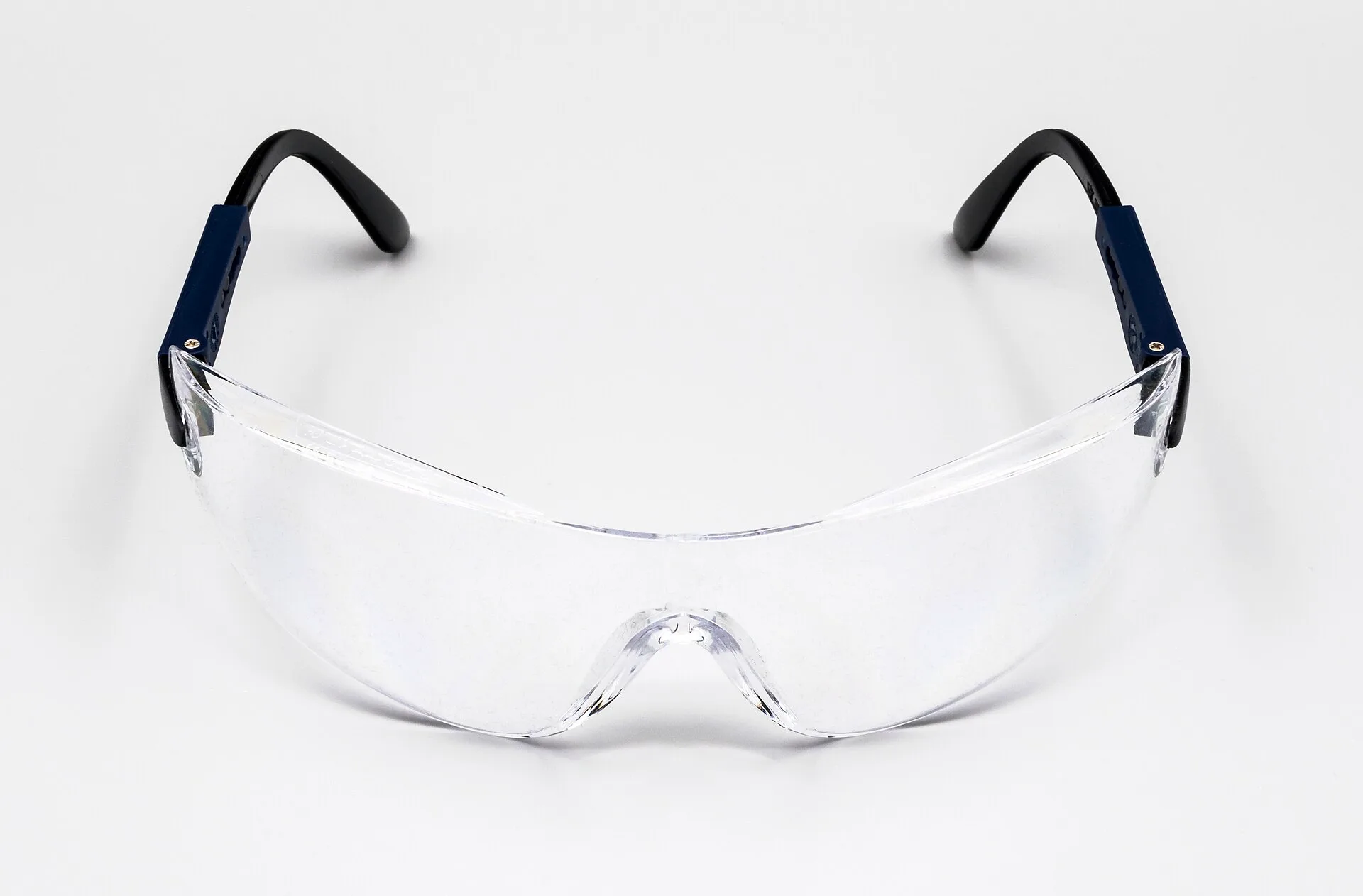Clear wraparound safety glasses with adjustable black temples on a white background